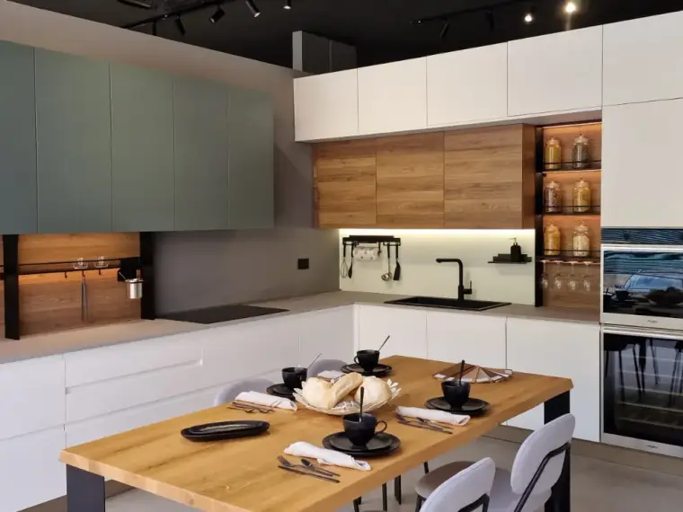 Cucina AR-DUE ad angolo verde salvia e bianco con zona soggiorno, top effetto pietra e tavolo in rovere, vista d'insieme