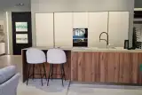 Cucina AR-DUE con isola, top in Neolith ceramica effetto pietra e fronte snack effetto noce, vista d'insieme con parete colonne