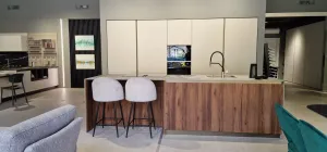 Cucina con isola centrale, top in Neolith ceramica effetto pietra e fronte snack effetto noce, vista d'insieme
