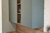 Pensili in verde salvia opaco e boiserie effetto legno della cucina AR-DUE con madia sospesa bianca