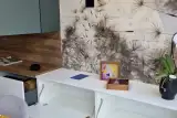 Zona soggiorno abbinata della cucina AR-DUE con madia sospesa bianca, pensili verde salvia e mensole a giorno