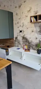 Zona soggiorno abbinata della cucina AR-DUE con madia sospesa bianca, pensili verde salvia e mensole a giorno