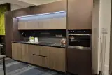 Cucina Mod. Metropolis a composizione lineare con colonna forno e parete verde decorativa