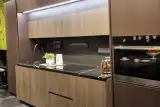 Cucina Mod. Metropolis vista frontale con ante effetto legno, top nero e forno a incasso