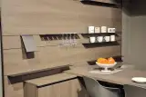 Zona pranzo della cucina Mod. Metropolis con tavolo, sedie e parete attrezzata in legno
