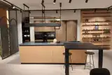 Parete di colonne in gessato noce della cucina Prima Gola Linear con forno e microonde Bosch neri, colonna frigo e boiserie a mensole laccata pesca