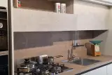 Zona cottura della cucina Stosa Young con piano cottura a gas, lavello inox, schienale in Noce Marino e vano a giorno con LED sottopensile