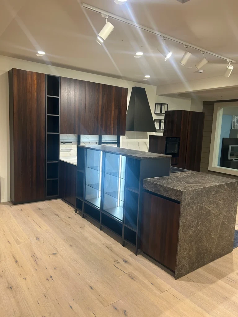 Cucina Glamour con isola scura vista laterale e vetrina illuminata